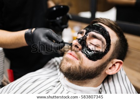 Relaxed man having purifying mask on face Royalty-Free Stock Photo #583807345