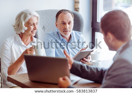 Positive aged couple consulting with insurance agent Royalty-Free Stock Photo #583813837