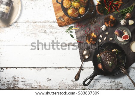Overhead view of colorful roast vegetables, savory sauces and salt served with grilled t-bone steak on a rustic wooden counter in a country steakhouse created digital illustration