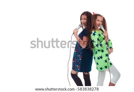 Two young girls with long hair with microphones in their hands singing songs on a white background