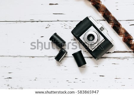 Retro camera, old photo film rolls  on white wooden background. top view