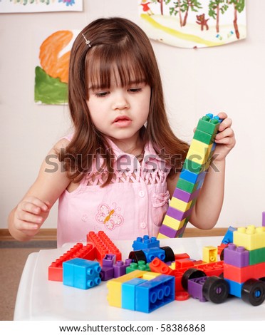 Child preschooler with construction set in play room.