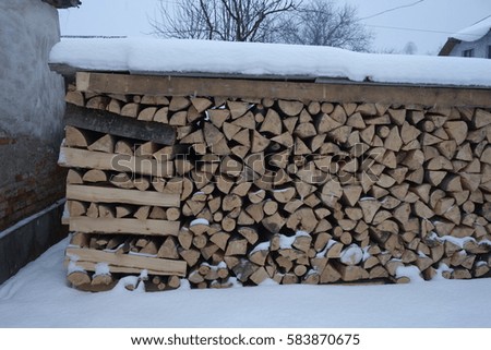 Firewood sprinkled with snow in winter