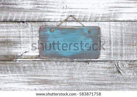 Blank wood teal blue sign hanging by rope on antique rustic white wooden background; painted background with copy space