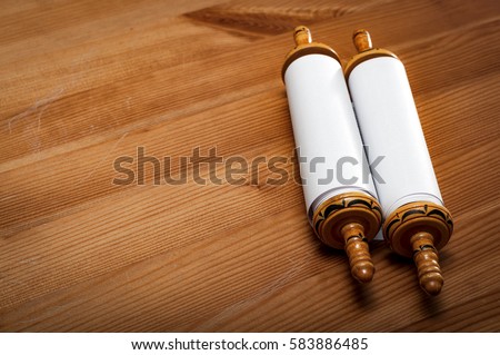 Judaism and religious text concept with a closed Torah on wooden background with copy space Royalty-Free Stock Photo #583886485