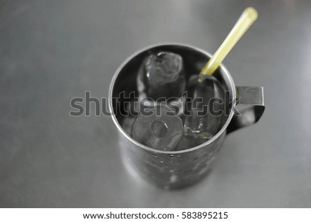 Ice with yellow tube in stainless glass