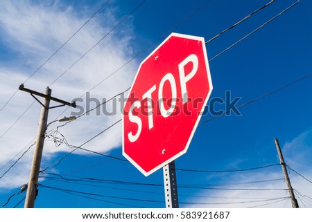 "Stop" sign in a small Midwest town with brilliant blue skies in background.