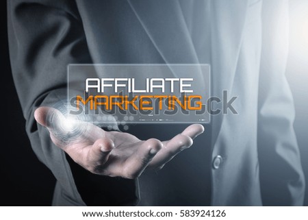 Hand holding transparent screen with text AFFILIATE MARKETING