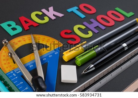Mathematical instruments over the corner of black paper with text back to school. Back to school with mathematical tools concept.
