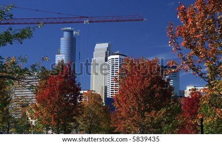 City skyline with fall trees and crane boom