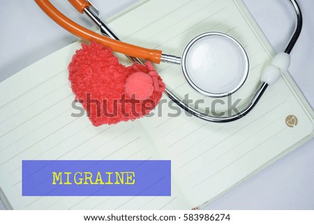 Stethoscope and heart shape on an open book with inscription MIGRAINE on a white background. Medical, Healthcare and Wellness concept.