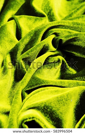 Green soft shiny Velvet dress material cloth. Velvet plush texture pattern. tailoring stitching concept. Shiny beautiful fashion fabric. Shiny clothing material sample. Creased fabric.