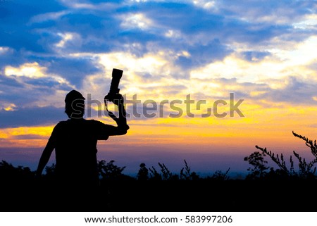 Silhouette of a photographer on sunset background.