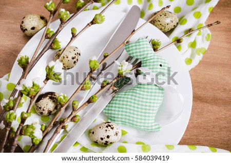 Festive table setting for Easter dinner with spring flowers and cutlery on wooden rustic table. Selective Focus.