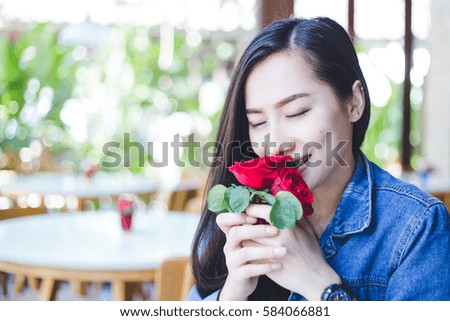 Young woman asian  woman sitting in a cafe, she was smelling roses with freshness.