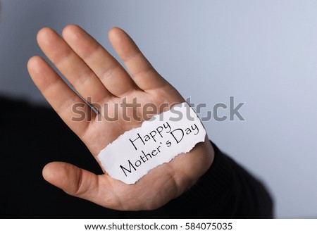 man holding a card congratulating women on Mother's Day
