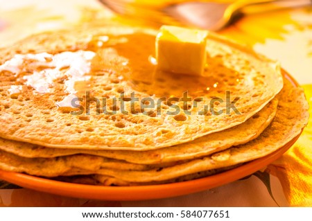 Pancakes. Honey. Butter. Maslenitsa. Delicious freshly-fried rumpy pancake is poured with liquid home-made honey and butter