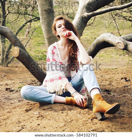 Fashion portrait of beautiful hippie young woman wearing boho chic clothes. Soft warm vintage color tone. Artsy bohemian style. Outdoors, tribal glam, suede ankle boots, kimono
