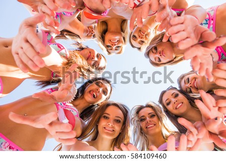 Ten beautiful girls models standing round in bikinis. Down view.