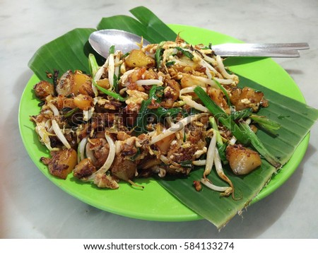 Penang famous hawker street food fried rice carrot cake "Char Koay Kak" with egg and bean sprouts. Royalty-Free Stock Photo #584133274