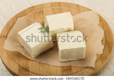 Feta cheese with dill over wooden background