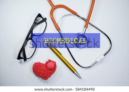 Stethoscope and heart shape on an open book with inscription BIOMEDICAL on a white background. Medical, Healthcare and Wellness concept.