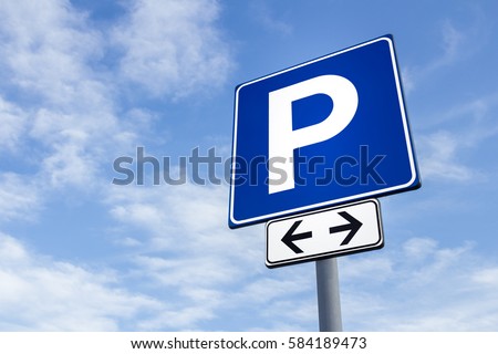 Car parking directional sign against a partly cloudy sky background