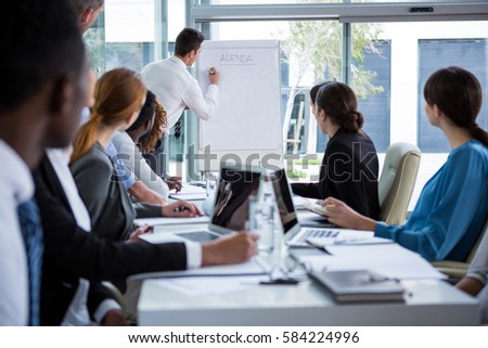 Businessman discussing on white board with coworkers in office