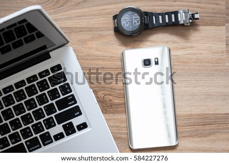 Laptop with Smart phone and Hand Watch on Wooden Background
