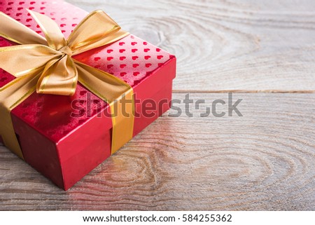 Gift box with satin ribbon on old wooden table