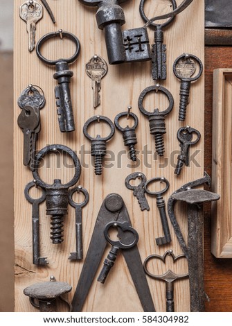 various old keys hanging on a wooden wall