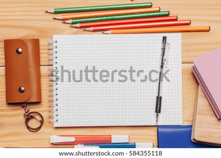 business card, notebook, sunglasses, pens, markers and scissors on the wooden background