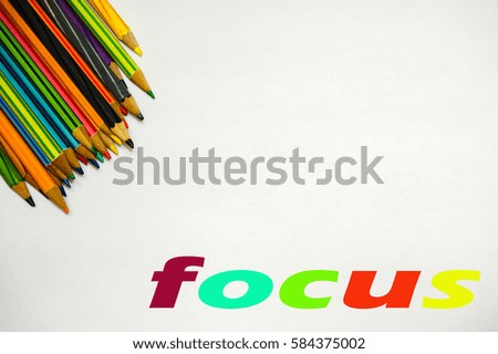 Color pencils with "focus" word isolated on white background. Education frame concept