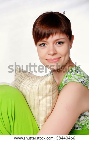 Young lovely brunette in green pajamas relaxing on sofa