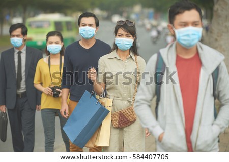 Citizens walking on the street in masks because of danger of epidemic Royalty-Free Stock Photo #584407705