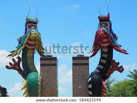 two colorful sculpture dragons against blue sky