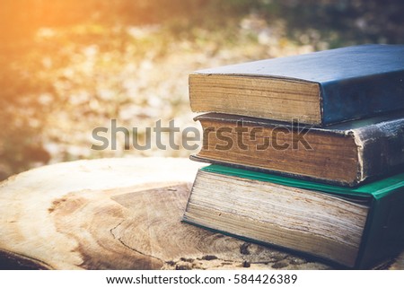Ancient books on a wooden table , literacy and knowledge concept Royalty-Free Stock Photo #584426389