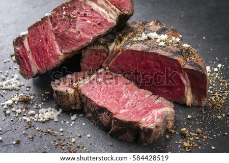 Barbecue dry aged Wagyu Rib Eye Steak as close-up on a slate Royalty-Free Stock Photo #584428519
