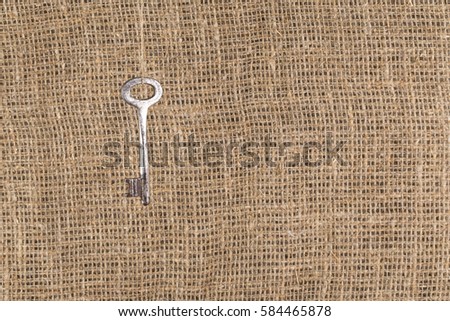 Old metal key on a neutral background for decoration