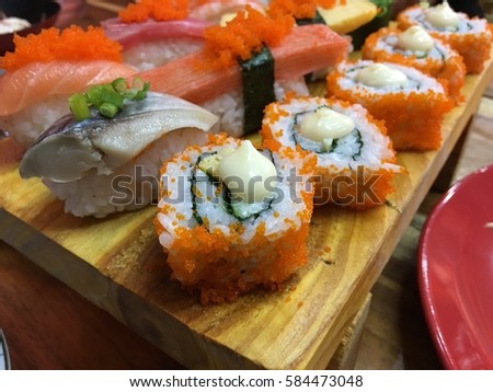 Sushi Set sashimi and sushi rolls served on stone slate Royalty-Free Stock Photo #584473048