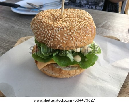 Home made hamburger with lettuce and cheese Royalty-Free Stock Photo #584473627