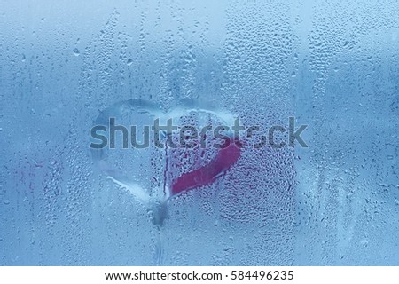 Rain, the inscription on the sweaty glass - love and heart. The picture in the heart on the sweaty glass of the window