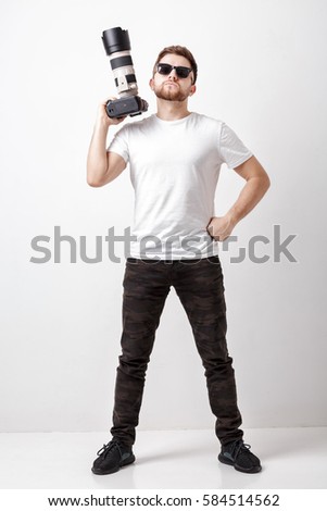 professional photographer in t-shirt use digital camera with lon