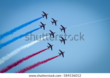 Performance of Patrouille de France military aircraft aerobatic group, making french flag trace in the air during air show Royalty-Free Stock Photo #584536012