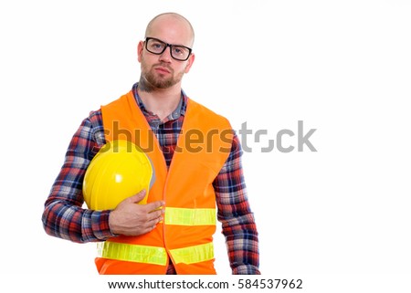 Studio shot of young bald muscular man construction worker holding safety helmet