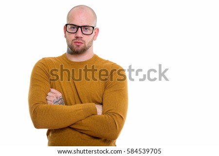Studio shot of young bald muscular man wearing eyeglasses with arms crossed