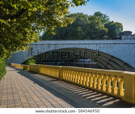 the old stone bridge and the plane-tree Avenue on the embankment of the Sochi river