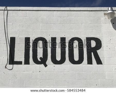 Liquor store sign on a white wall 