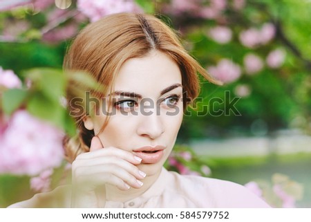 Spring portraits gorgeous young woman on  cherry blossom background