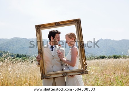Newlyweds holding vintage picture frame